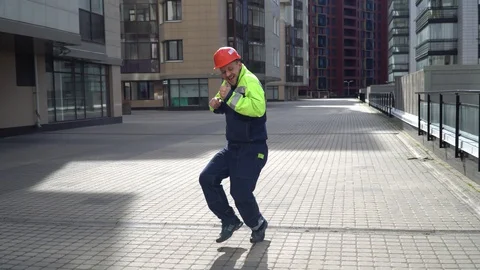 Young cheerful happy builder in an orange helmet and work 4k shot Stock Footage 130140535