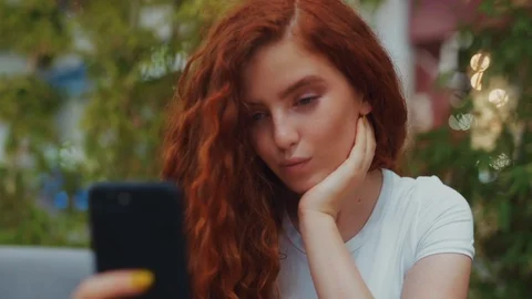 Young cheerful woman posing while photographing herself on smart phone camera Stock Footage 114250647
