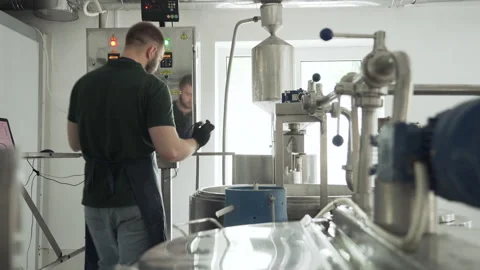 A young cheesemaker controls the temperature of the cheese mixture.  Vidéo 177590979