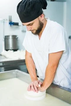 Young cheesemaker man, working curd shaping into mozzarella cheese in dairy Stock Photos