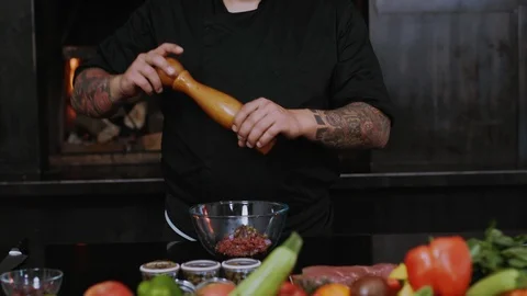 Young chef adds spices to the dish cook food fresh in kitchen preparing dinner Stock Footage 100303802
