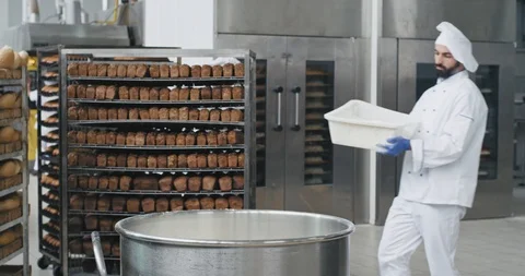 Young chef baker with a beard preparing the dough add some more flour in a big Stock Footage 112145015