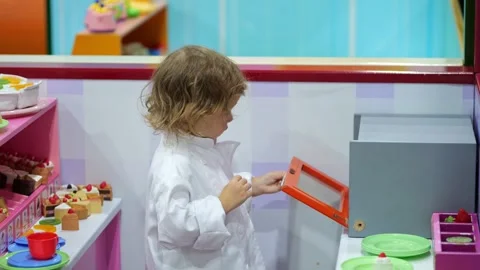 Young chef baking toy cakes in play kitchen Stock Footage 302152180