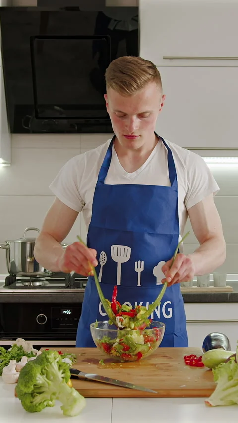 Young chef creating a fresh salad in a modern kitchen Stock Footage 341762066