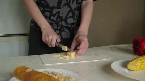 A young chef cuts cheese in the kitchen Stock Footage 322073940