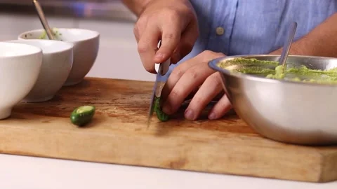 Young chef cutting herbs on a cutting board Stock Footage 153771942
