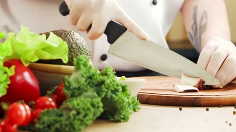 Young chef is cutting octopus in a modern kitchen. The man prepares food at home Stock Footage 153036112