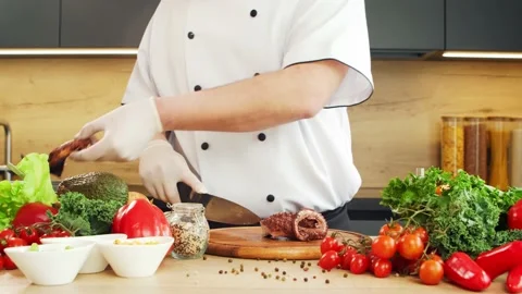Young chef is cutting octopus in a modern kitchen. The man prepares food at home Stock Footage 153965179