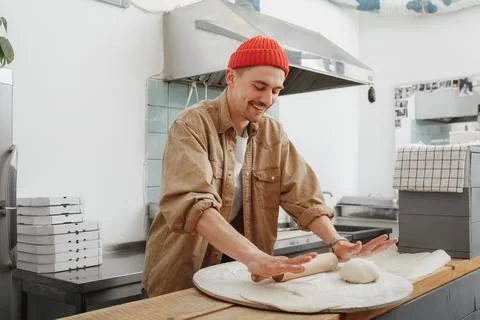 Young chef makes the dough in the cafe Stock Photos
