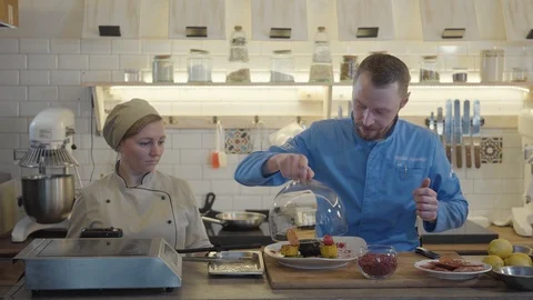Young chef with pastry chef using equipment adding smoke or steam to the dish Stock Footage 107732790