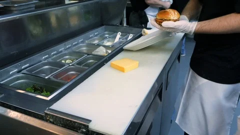 Young chef prepares hamburger bun at station Stock-Footage 94281878