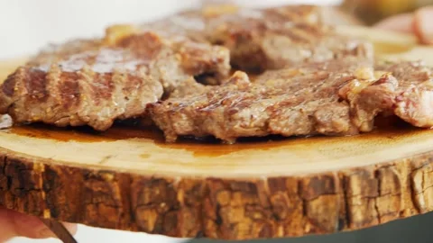 Young chef preparing grilled meat steak in a modern kitchen. The man prepares Stock Footage 152974138