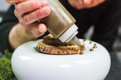 Young chef preparing modern molecular dish with sauce Stock Photos