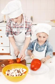 Young chef preparing vegetables in the kitchen Stock Photos