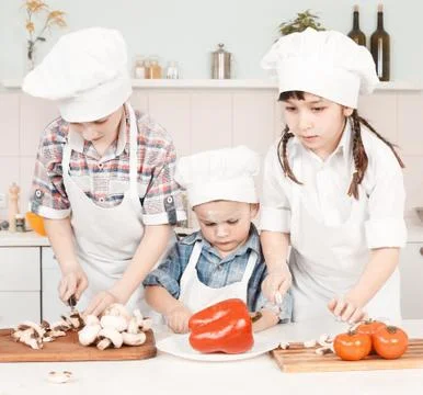 Young chef preparing vegetables in the kitchen Stock Photos