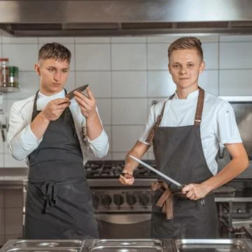 Young chef sharpening knives in the kitchen 스톡 사진