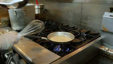 Young chef stirs in mixture to create sauce Stock-Footage 94257639