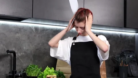 Young chef struggles with kitchen chaos while preparing fresh ingredients Stock-Footage 296317740