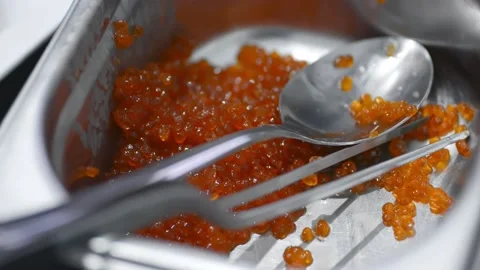 Young chef takes red caviar with spoon while cooking in restaurant kitchen irrl. Stock Footage 134863779