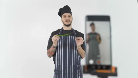 Young chef teaching online using smartphone camera to stream lesson Video stock 143636256