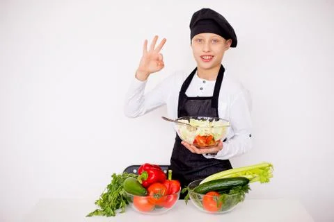 Young chef tries to salad isolate Stock Photos