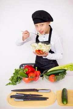 Young chef tries to salad isolate Stock Photos