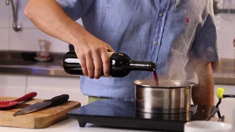 Young chef using red wine for a recipe Stock Footage 153771886