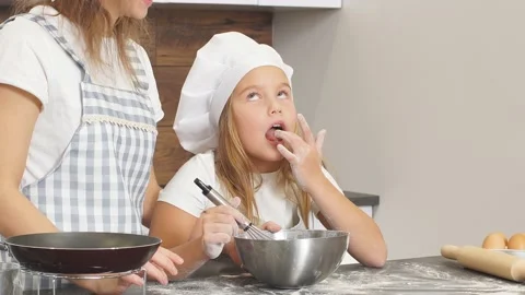 Young chefs are engaged in preparation of cake, litlle girl tastes the dough Video stock 124073609