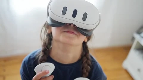 Young child actively engaging with an immersive and exciting virtual reality Stock Footage 314943752