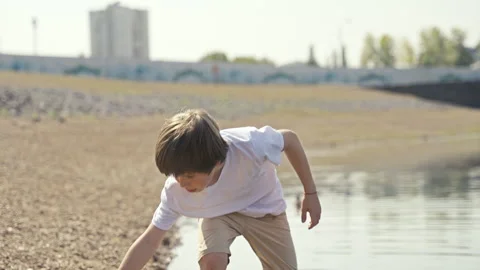 A Young Child Adventure Exploring the Waters Edge on a Bright and Sunny Day in Stock Footage 313327709