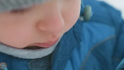 Young child blows shimmering bubble. Toddler focuses intently on making bubble Stock Footage 331952573