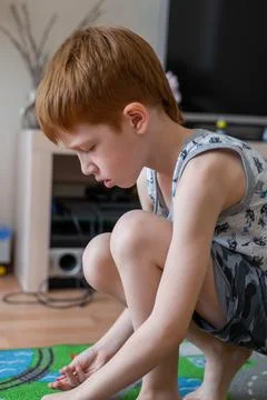 Young child boy plays constructor at home on the floor. Preschool education.  Stock Photos