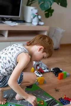 Young child boy plays constructor at home on the floor. Preschool education.  Stock Photos
