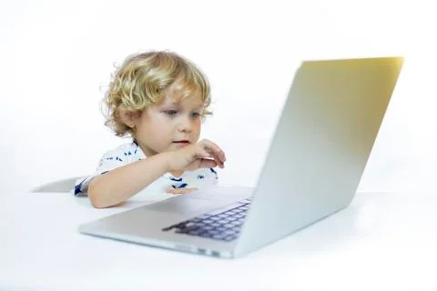 A young child with cheerful expression between 4 and 5 years old sitting at a Stock Photos