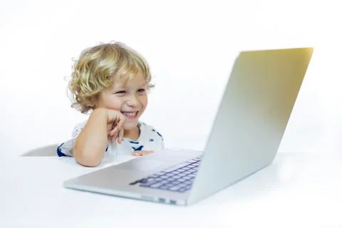 A young child with cheerful expression between 4 and 5 years old sitting at a Stock Photos