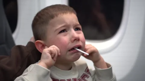 Young child crying during an airplane flight because of ear discomfort caused Stock-Footage 342069738