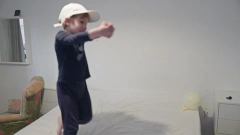 Young child dancing on bed in bedroom Stock Footage 308681789
