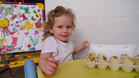 Young child decorating Easter eggs, a fun activity for a Christian holiday .. Stock Footage 330108985