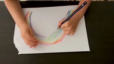 Young child draws abstract rainbow picture on paper sheet Stock Footage 154748829