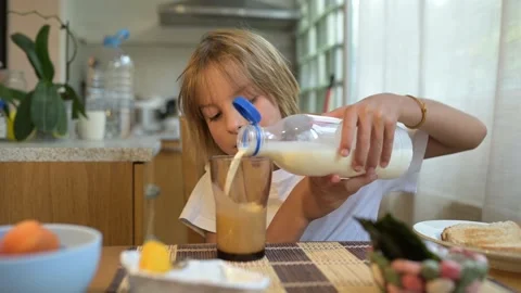 Young child drinking milk at breakfast table in cozy kitchen. Peaceful morning Stock Footage 315565326