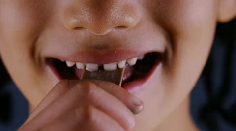 Young child eating a small block of chocolate Stock Footage 68089559