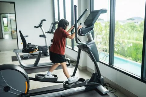Young child exercising on elliptical machine in modern gym, focusing on fit.. Foto stock