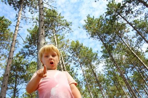 Young child in forest pointing at camera Stock Photos