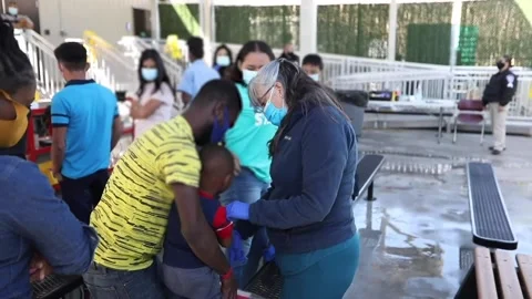 Young child gets checked over by medic at El Paso Processing Center, Texas Stock Footage 151251482