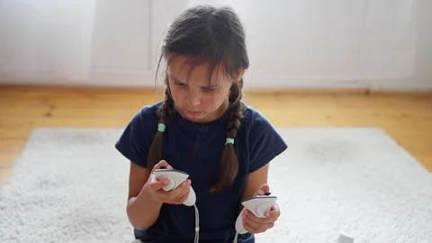A young child happily explores technology in the comfort of home, holding Stock Footage 316972541