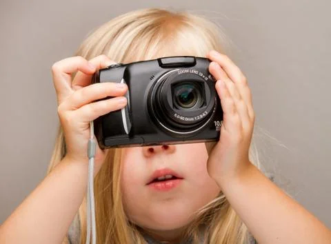 Young child holding a camera taking a picture Stockfoto's