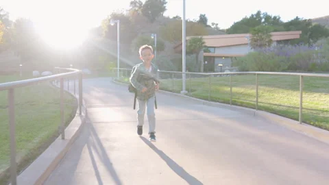 A young child is joyfully running through a sunny park, full of life and Stock Footage 305481590