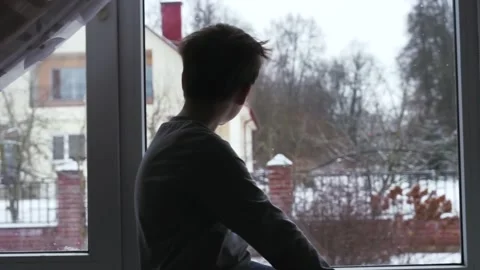 Young child kid sitting on window sill looking at snowflakes. snowing winter  Stock Footage 142812753