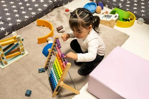 Young child learning math using colorful abacus counting tool Stock Photos