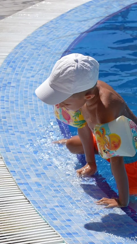 Young Child Learning to Swim in Blue Pool with Arm Floaties 스톡 동영상 346926189
